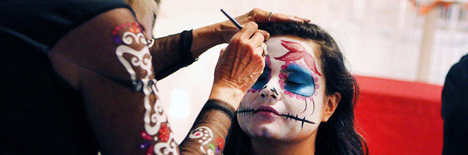 Student painting face designs during Dia de los Muertos. Photo credit: Anna Gallagher