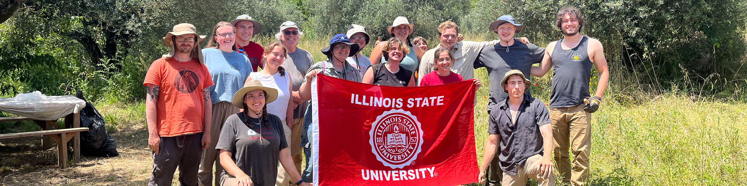Latin students posing holding an Illinois State flag